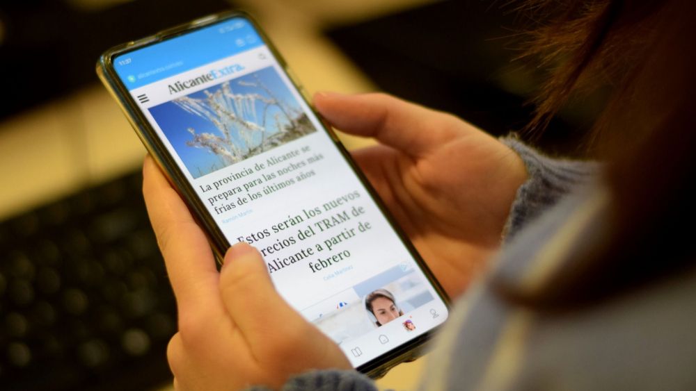Una persona llig Alacant Extra en el mòbil