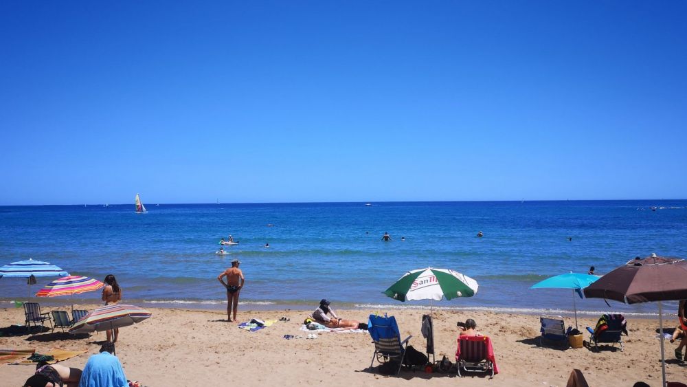 Varias personas en la playa durante la ola de calor en Alicante