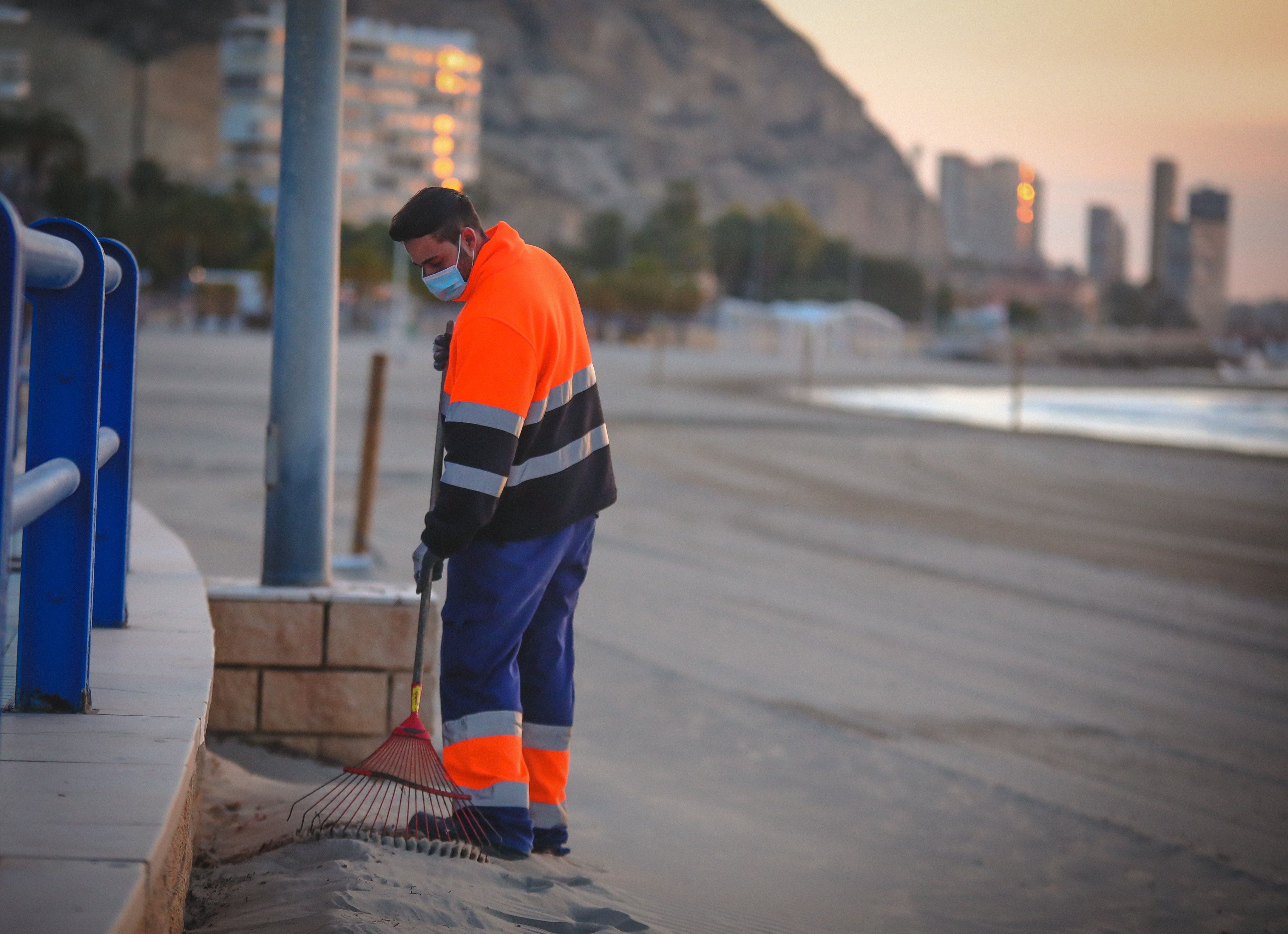 Operario de limpieza en la playa del Postiguet de Alicante
