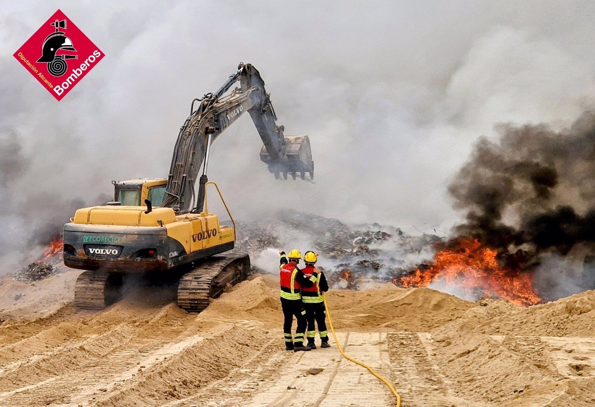 Dos bombers treballen en les labors de coordinació per a l'extinció de l'incendi de Xixona