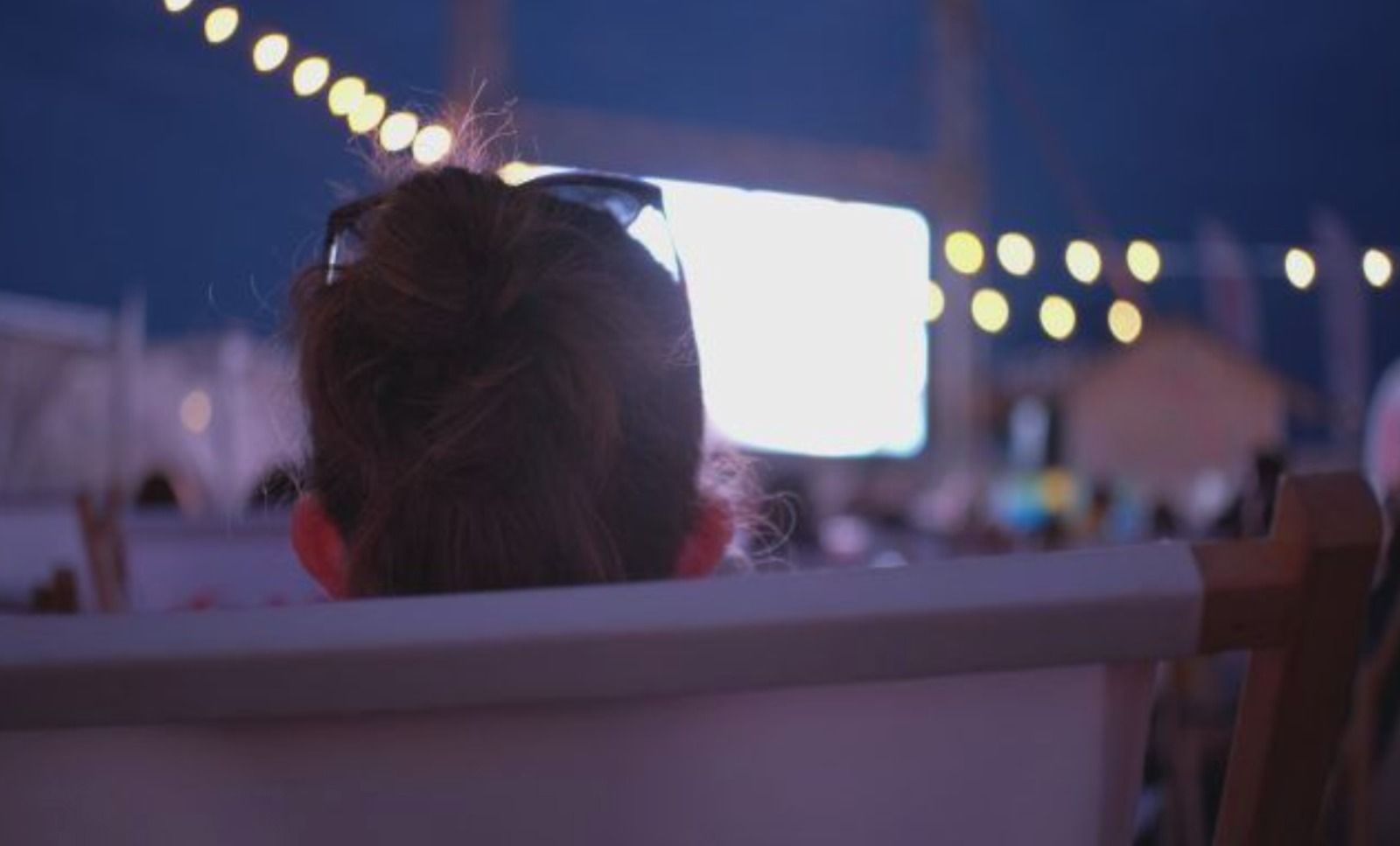 Una persona disfruta de una película en el cine de verano