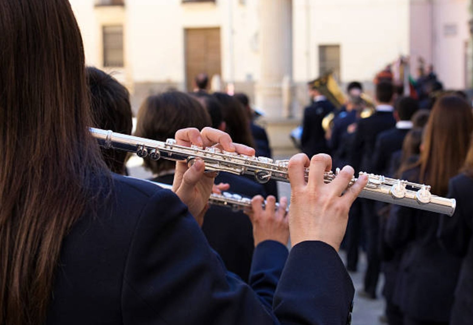Una xica toca una flauta travessera en una orquestra
