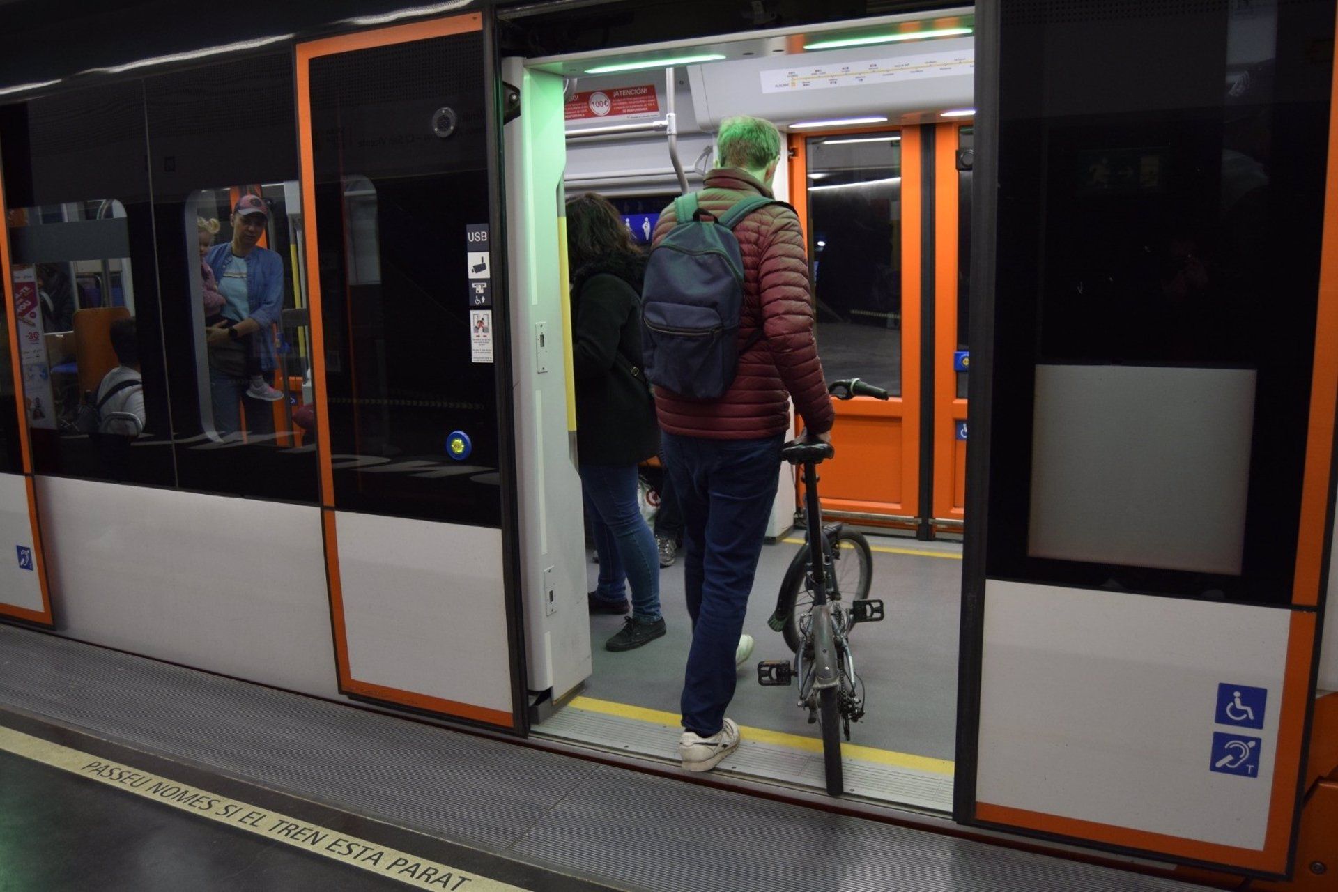 Una persona puja amb bicicleta al TRAM
