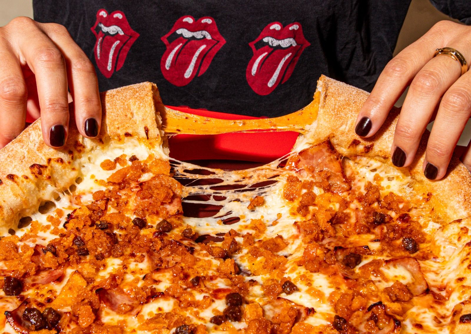 Una persona coge una porción de pizza