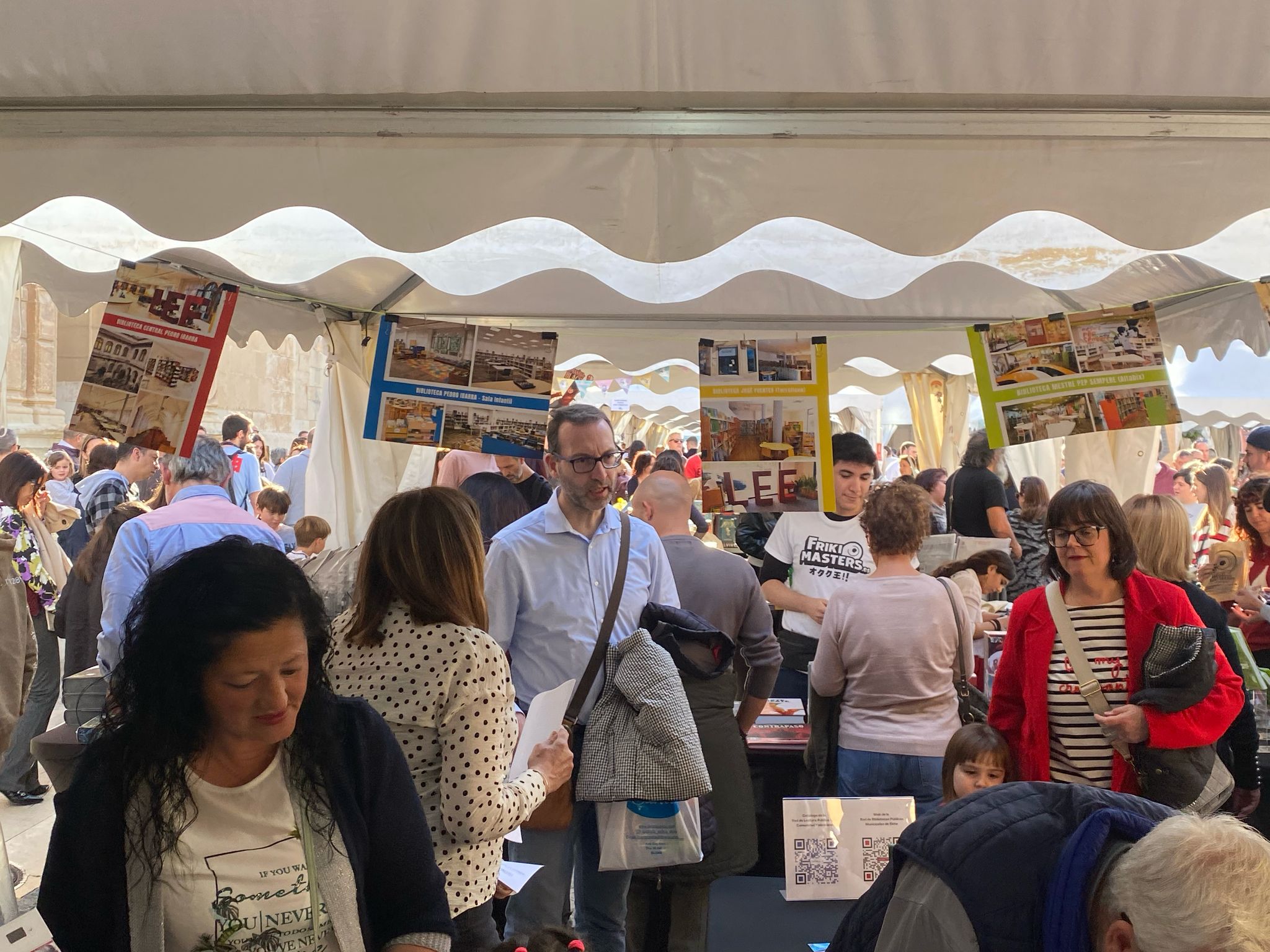 Varies persones en la Fira del Llibre d'Elx 2025