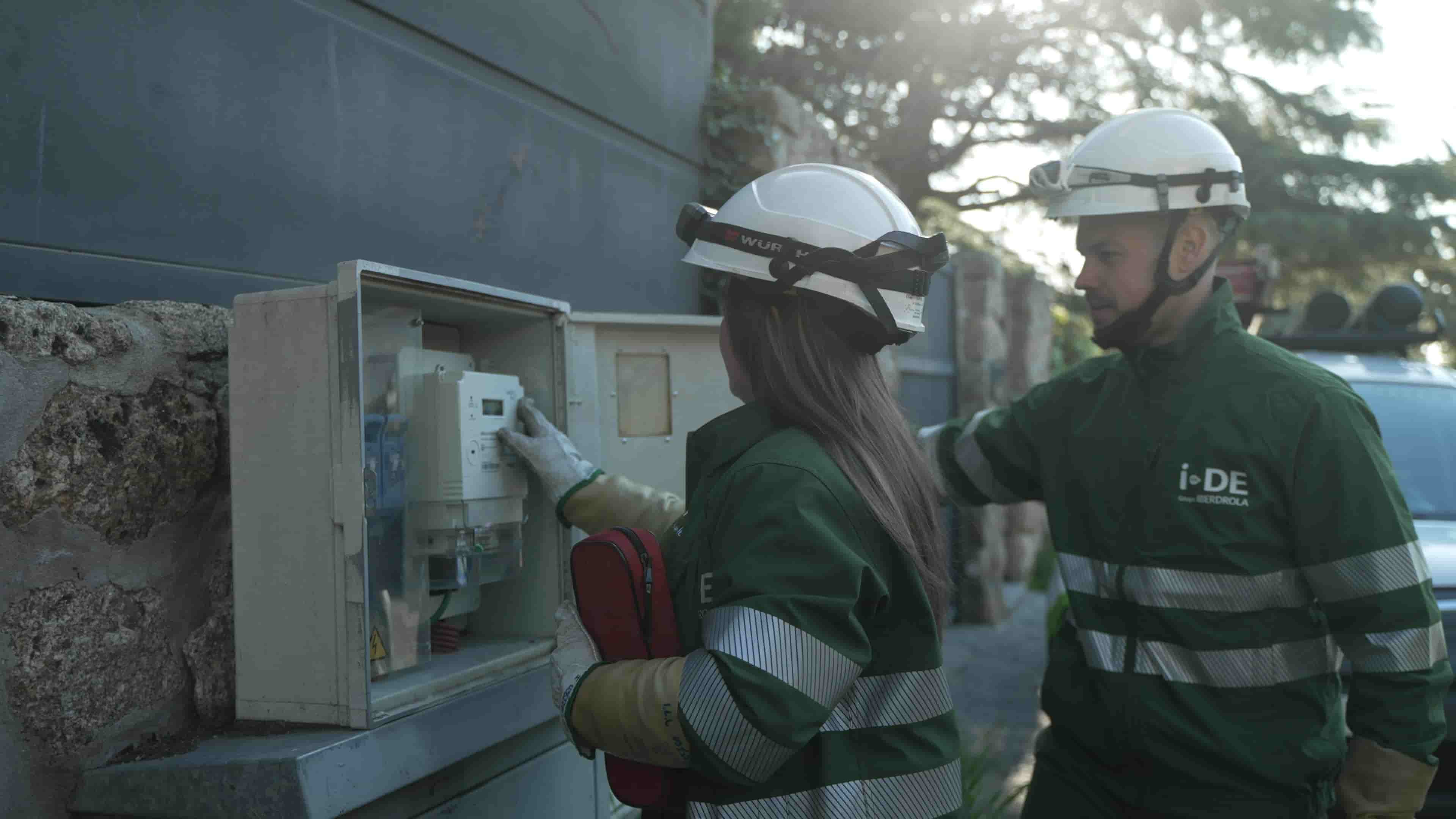 Dos operaris de la llum al costat d'un comptador a Alacant