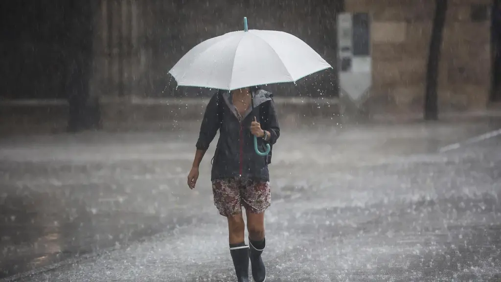 Una persona bajo una intensa lluvia en Alicante