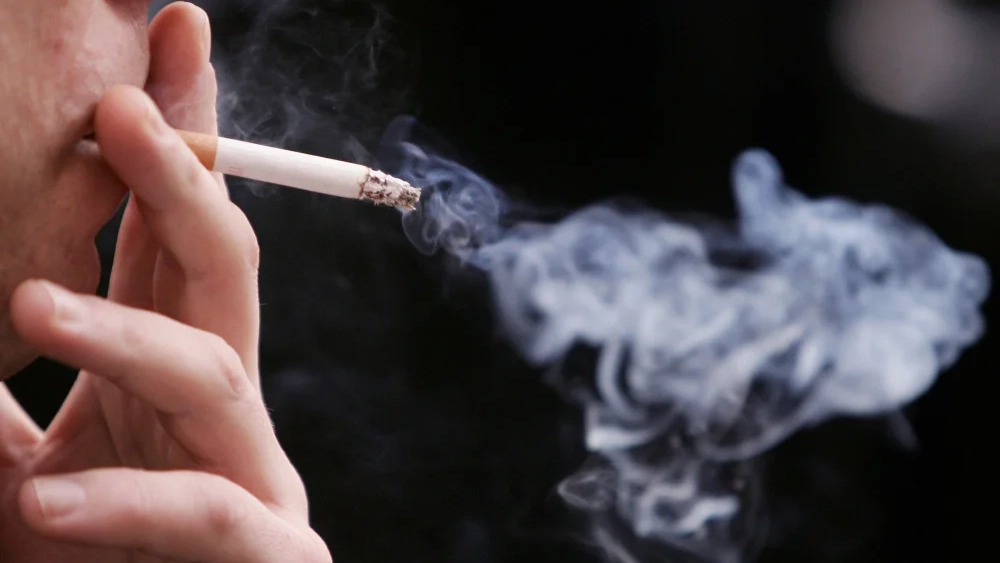 Una persona fumando en un espacio público Una persona fumando en un espacio público