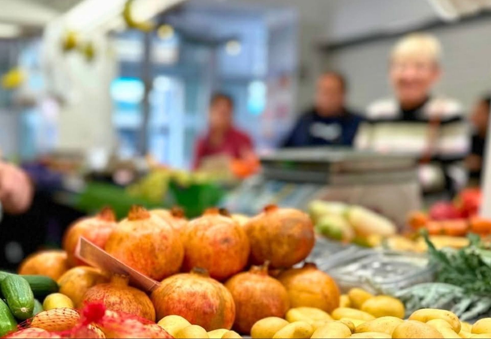 Diverses persones compren en un lloc de verdures en el Mercat Central d'Alacant