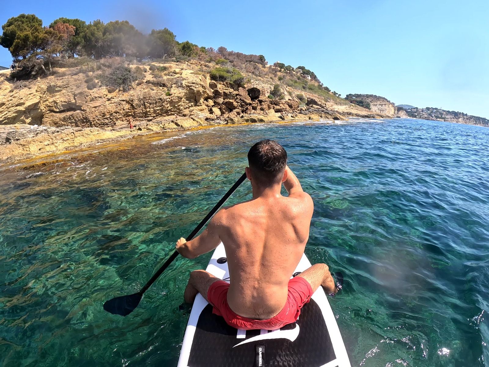 Un joven realiza una excursión en Kayak en una de las calas de aguas cristalinas de Benissa