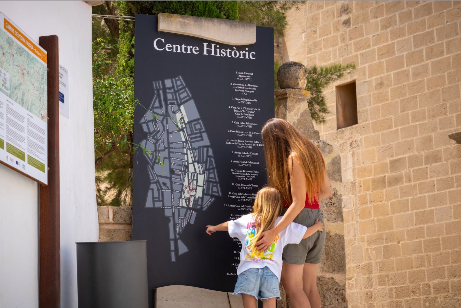 Una madre y su hija visualizan el mapa del centro histórico de Benissa