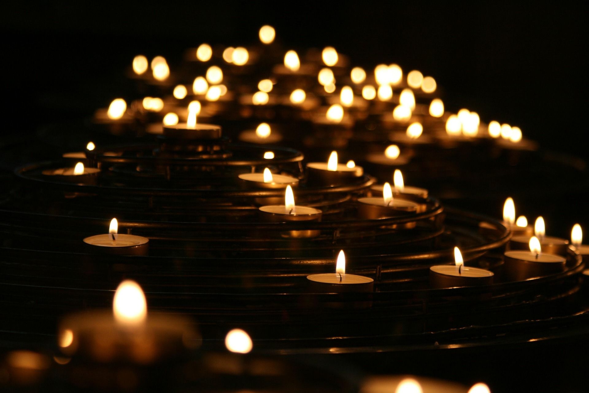 Una imagen de velas encendidas durante un evento por la noche