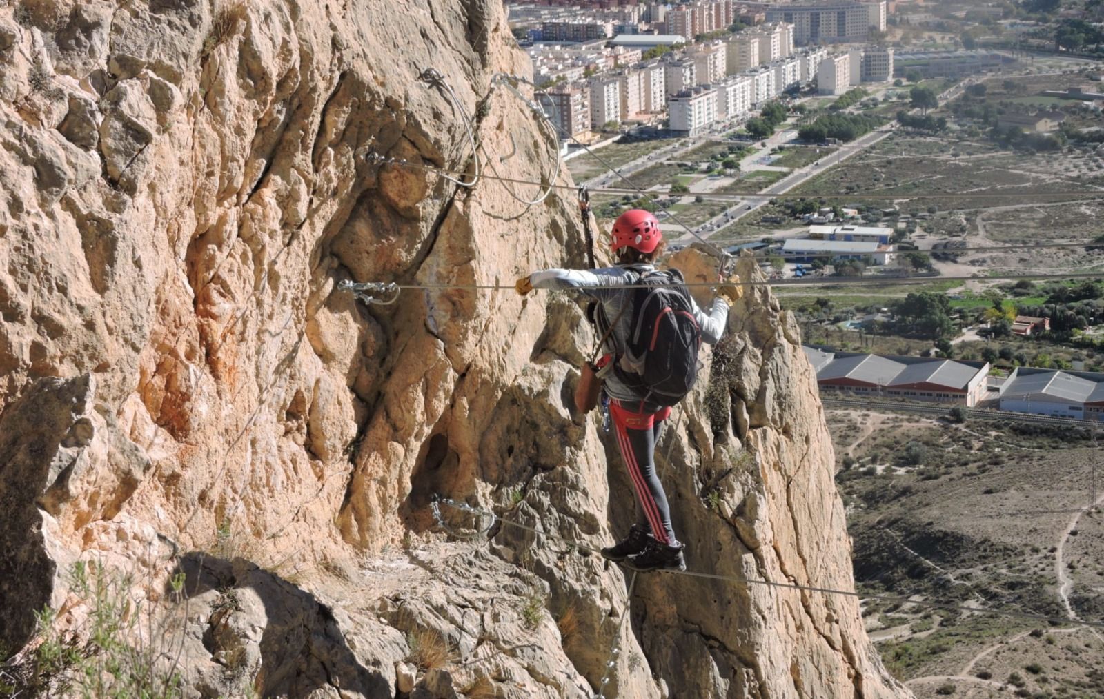 Una dona en una passarel·la penjant en la via ferrada de El Bolóna Elda