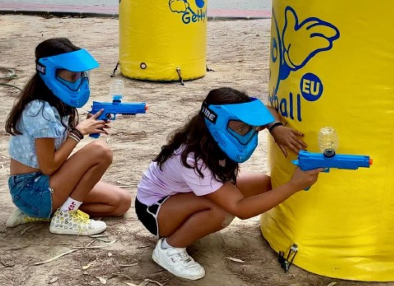 Dos xiquetes juguen a la guerra de pintura amb boles de gel