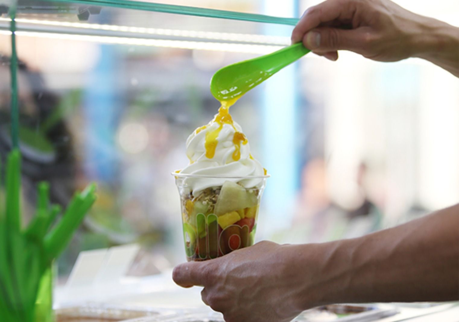 Un empleado de 'Llaollao' prepara un yogur helado