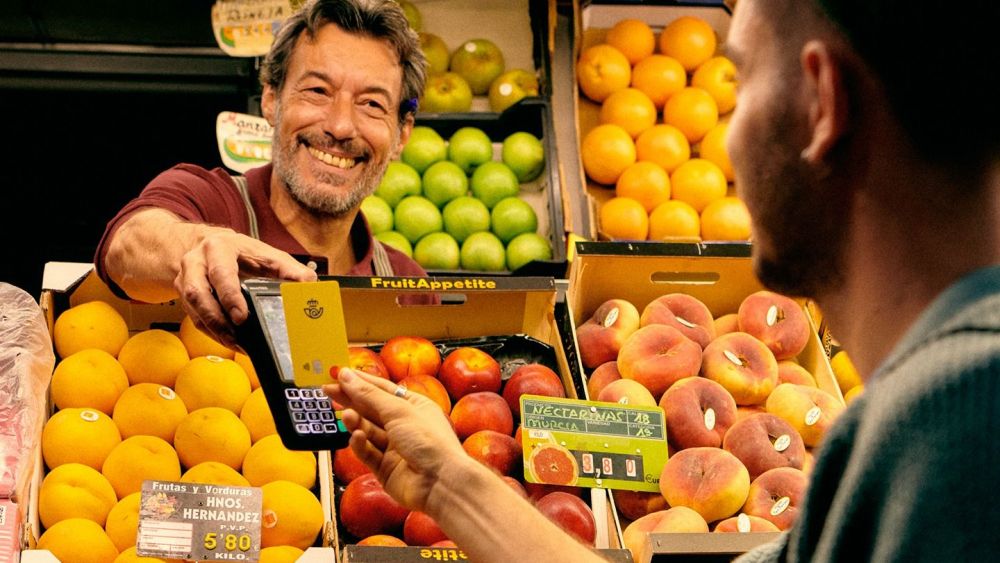Una persona utiliza la tarjeta prepago de Correos en una frutería