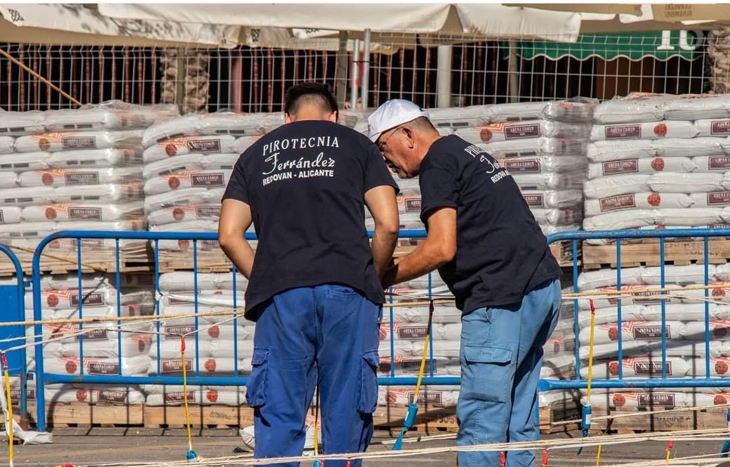 Dos trabajadores de Pirotecnia Ferrández ultiman los preparativos de una mascletà en València (Foto: Julio Marín)