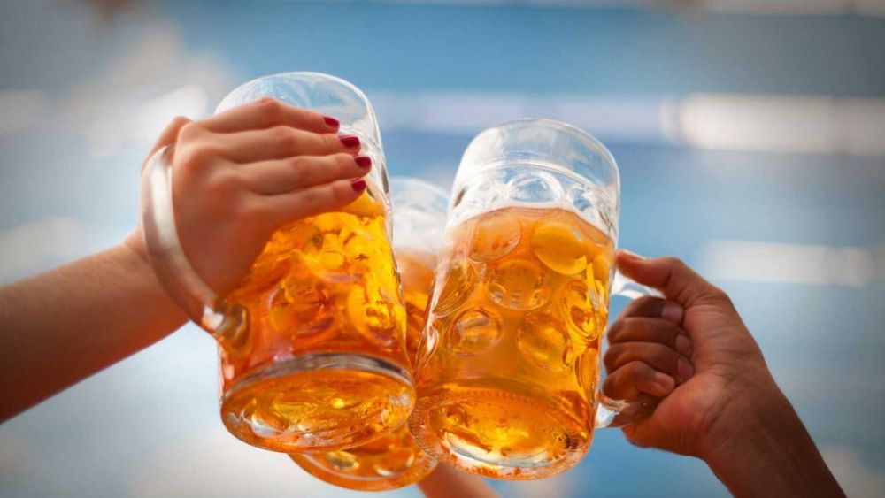Persones brindant amb pitxers de cervesa