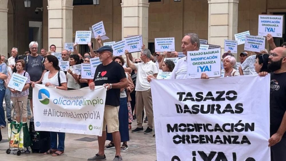 Veïns i veïnes amb pancartes durant la concentració contra la nova taxa d'escombraries a Alacant Veïns i veïnes amb pancartes durant la concentració contra la nova taxa d'escombraries a Alacant