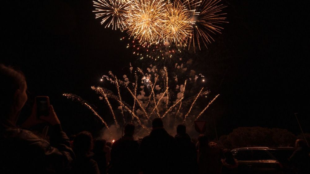 Diverses persones gaudixen d'un castell de focs artificials a Alacant (Foto: Pablo Leal - Getty)