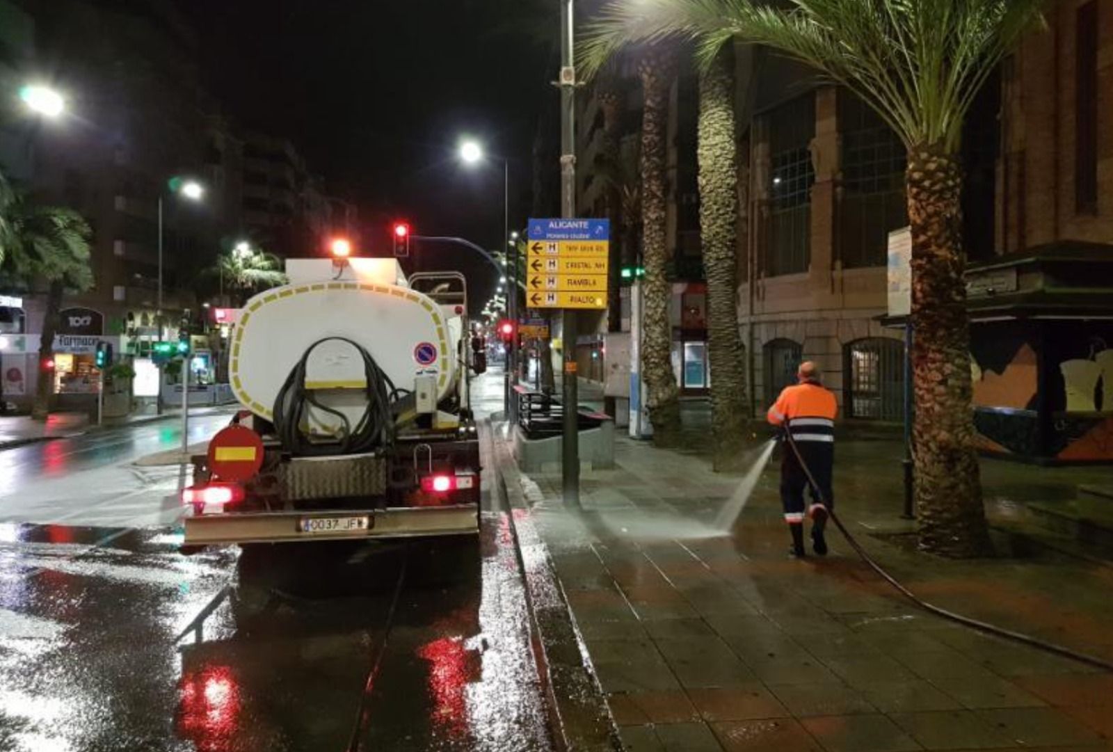 Un operario de la limpieza en Alicante realiza un baldeo en el entorno del Mercado Central