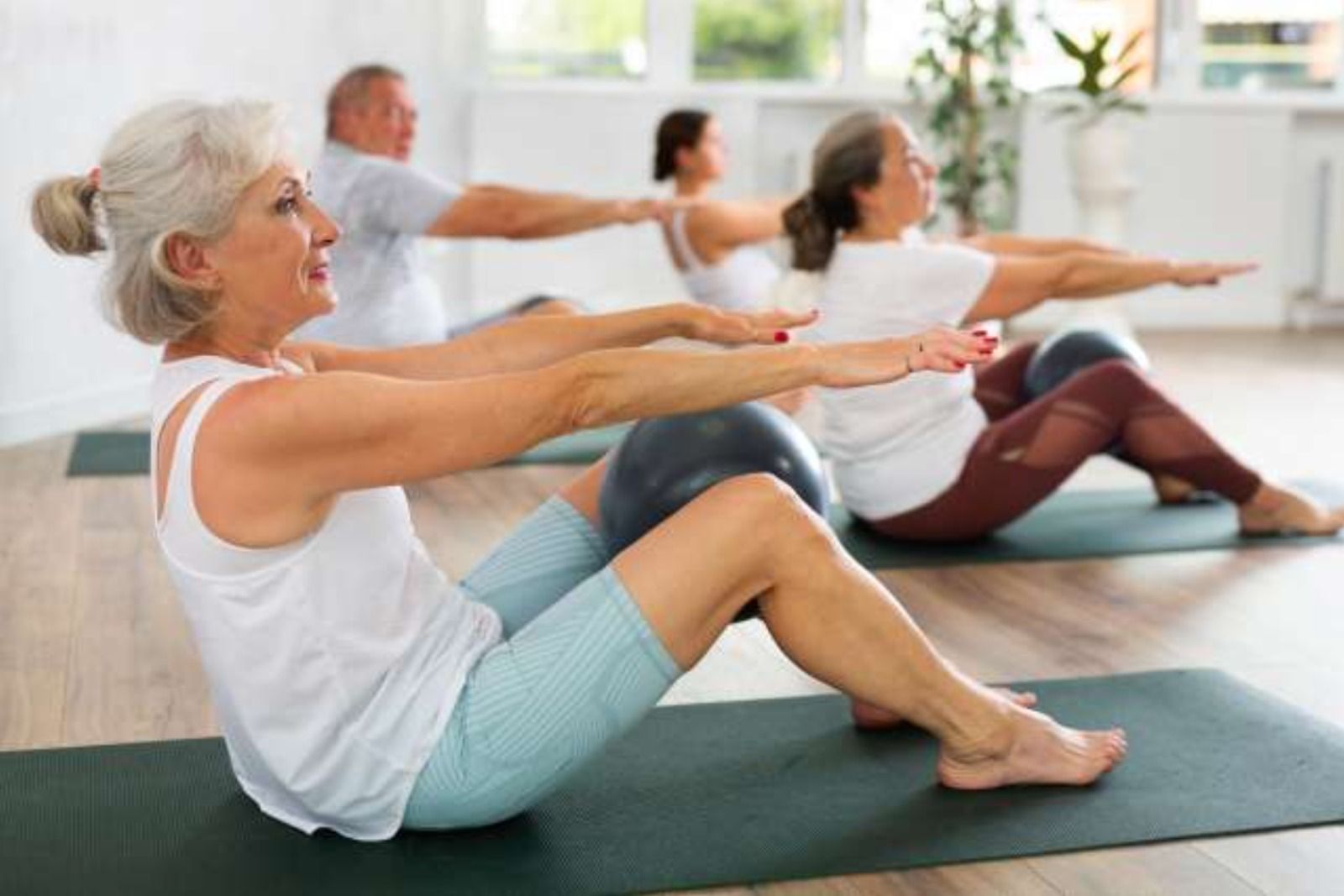 Varias personas realizan ejercicios de pilates