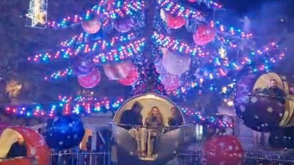 Diverses persones utilitzen l'arbre giratori de Nadal