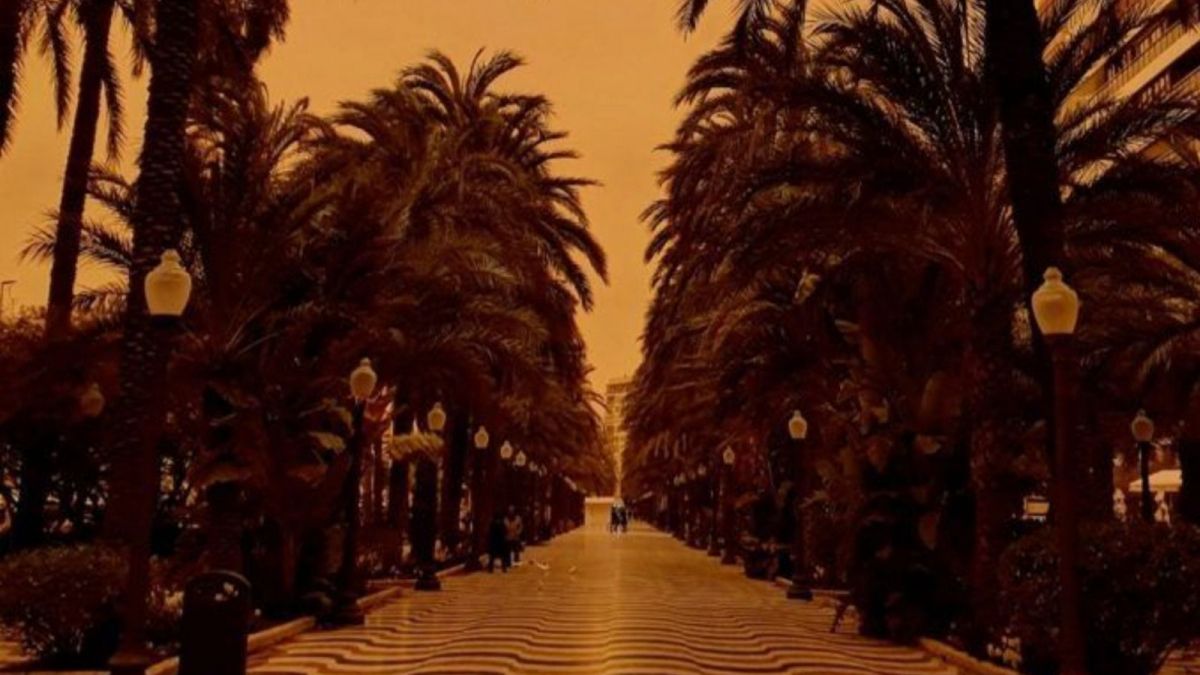 Cel ennuvolat amb to taronja en l'Esplanada d'Alacant per una massa de pols sahariana