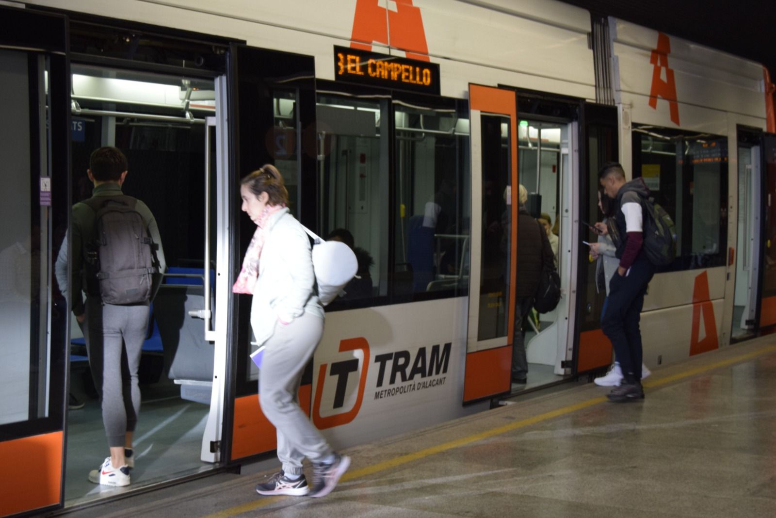 Varias personas suben al TRAM en la estación del Marq