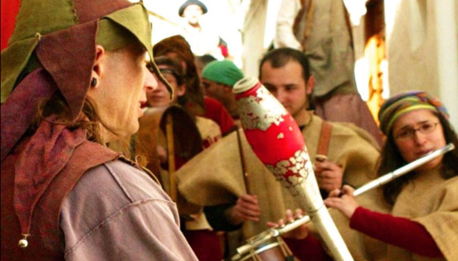 Músics caracteritzats de trobadors en un mercat medieval