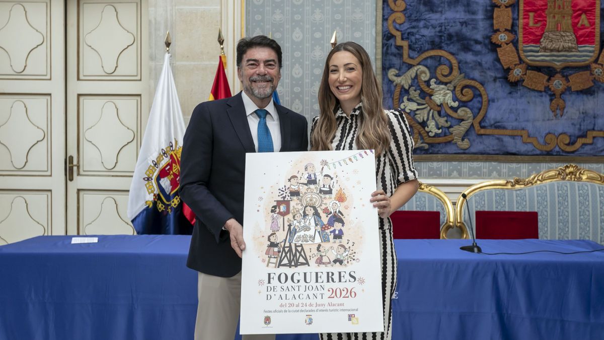El alcalde Luis Barcala y la autora María Martínez posan con el cartel de las Hogueras 2026