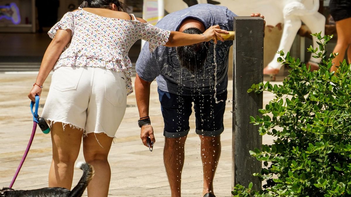 Una persona se refresca en una fuente de Alicante por el calor