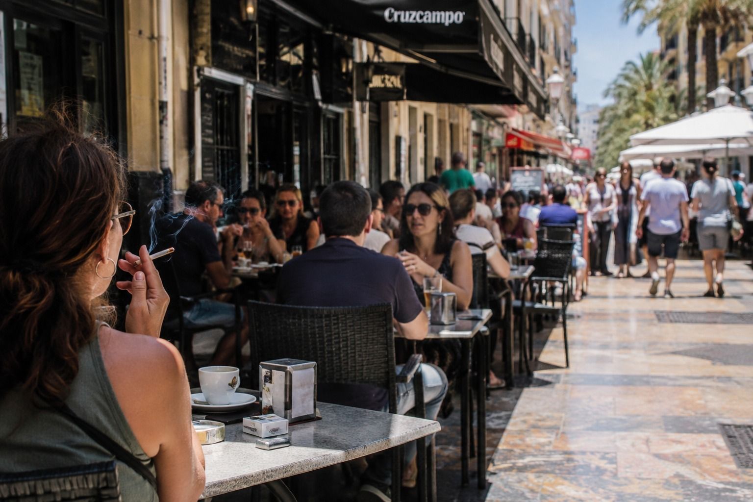 Una mujer fuma en la terraza de un bar en Alicante Una mujer fuma en la terraza de un bar en Alicante
