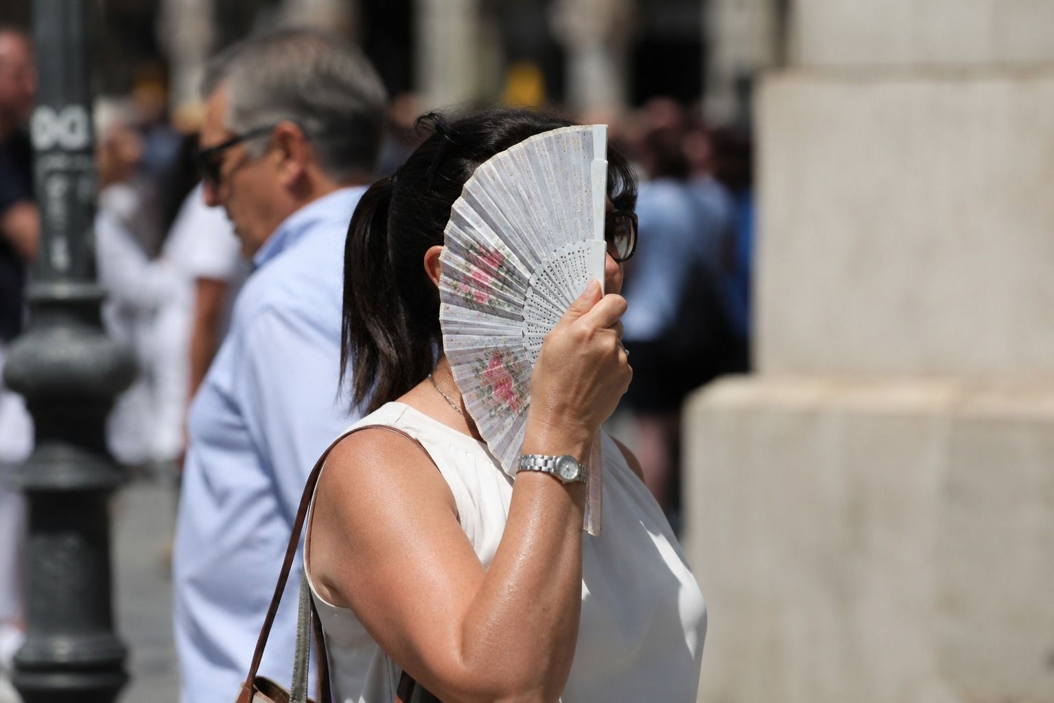 Una mujer se tapa la cara con un abanico un día de calor en Alicante Una mujer se tapa la cara con un abanico un día de calor en Alicante