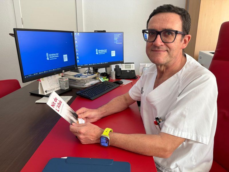 Un profesional sanitario de Elche con uno de los trípticos de la Nit de l'Albà Un profesional sanitario de Elche con uno de los trípticos de la Nit de l'Albà
