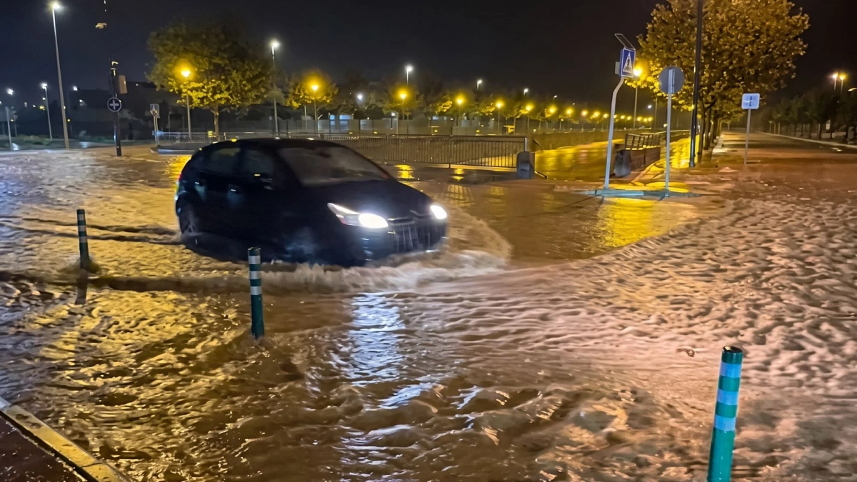Un coche atraviesa una calle inundada por la DANA Adam