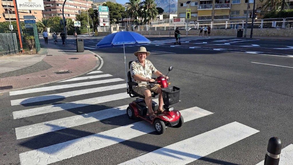 Un hombre utiliza un 'scooter' eléctrico por una calle de Benidorm (Editada con IA) Un hombre utiliza un 'scooter' eléctrico por una calle de Benidorm (Editada con IA)
